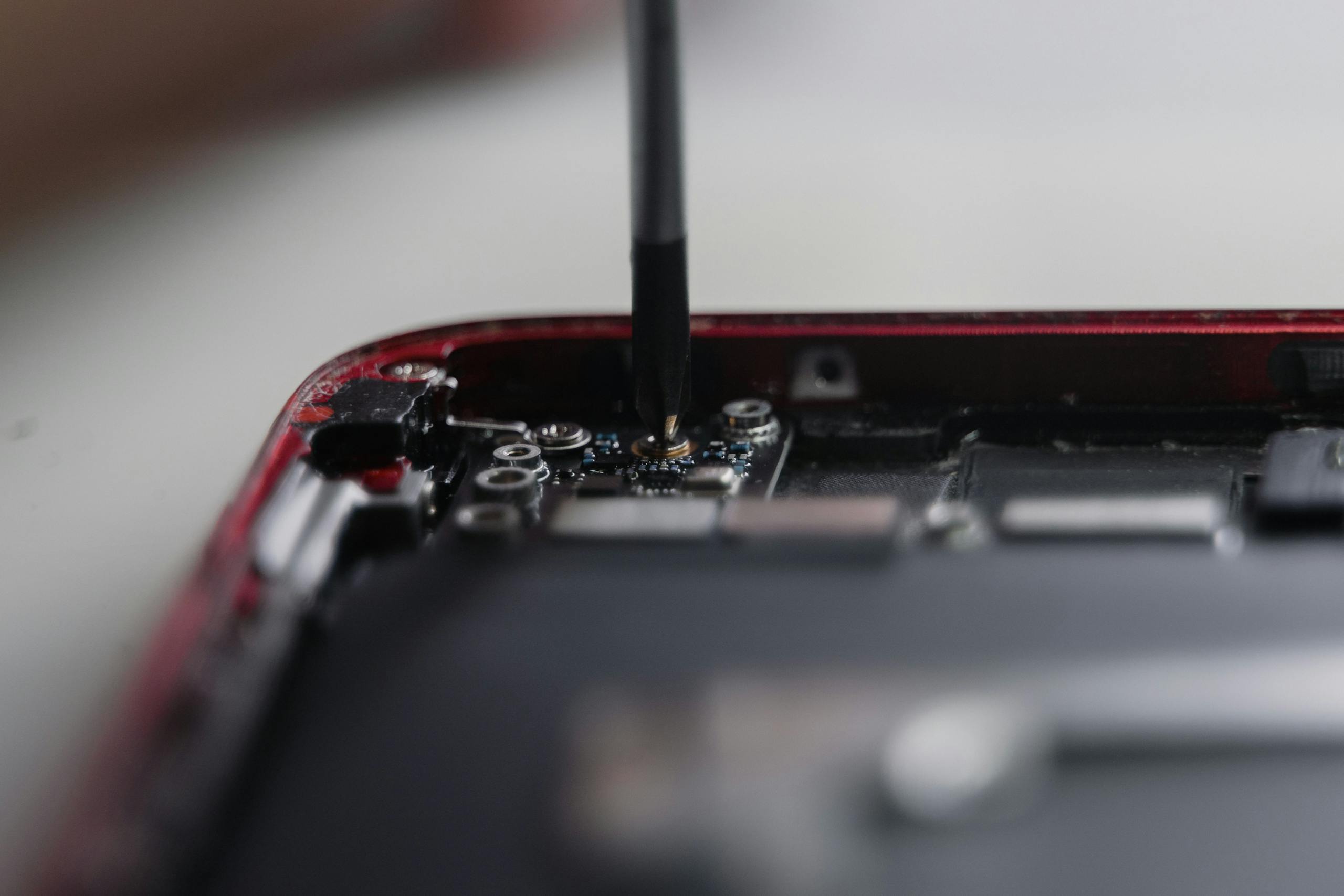 Professional repair of a smartphone's internal components using precise tools.